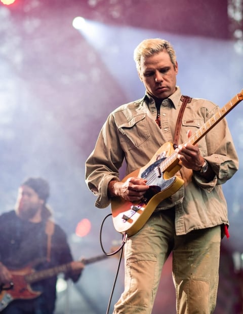 a guitarist on stage playing at Jazzfest