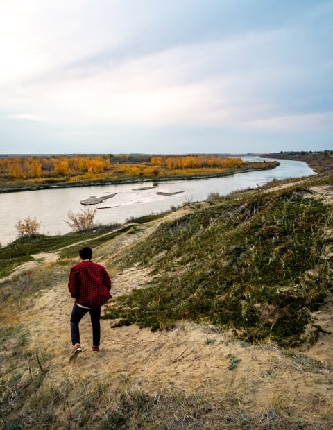 A man hiking along a path by a river