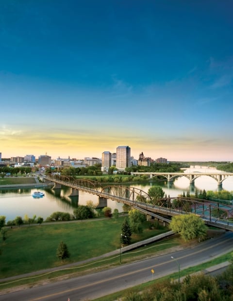 Aerial view of the city of Saskatoon with the highway in the foregound and the river and city in the background