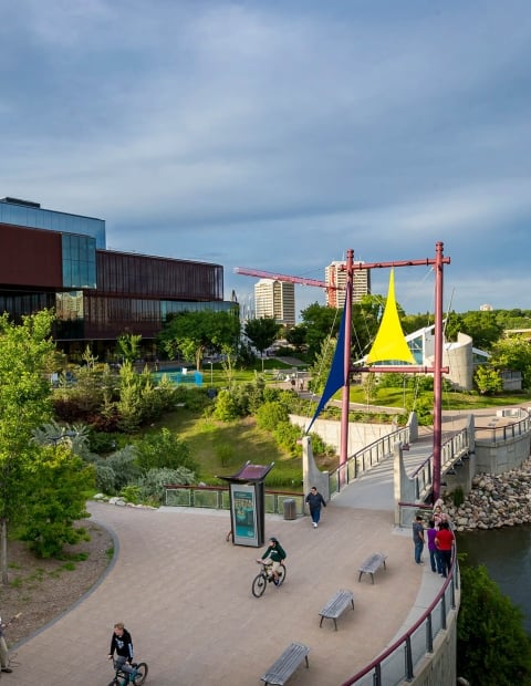 The boardwalk by the river with a large building in the background