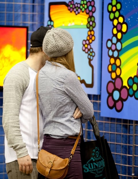 a couple looking at a large colourful painting