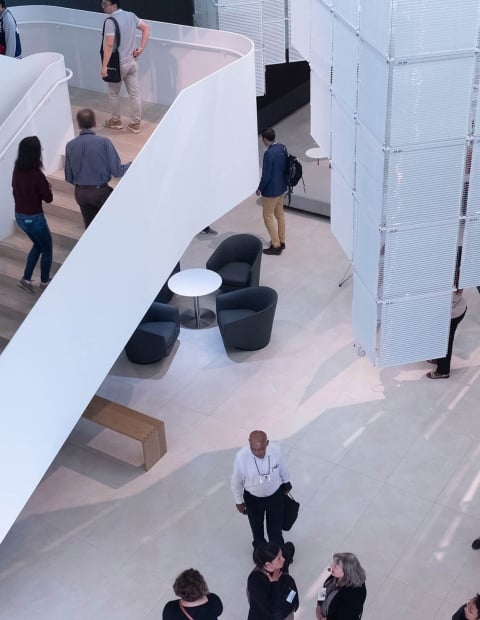 People walking in office lobby and large set of stairs