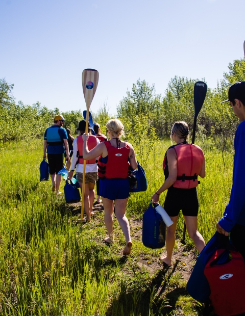 Canoers Walking with Paddles
