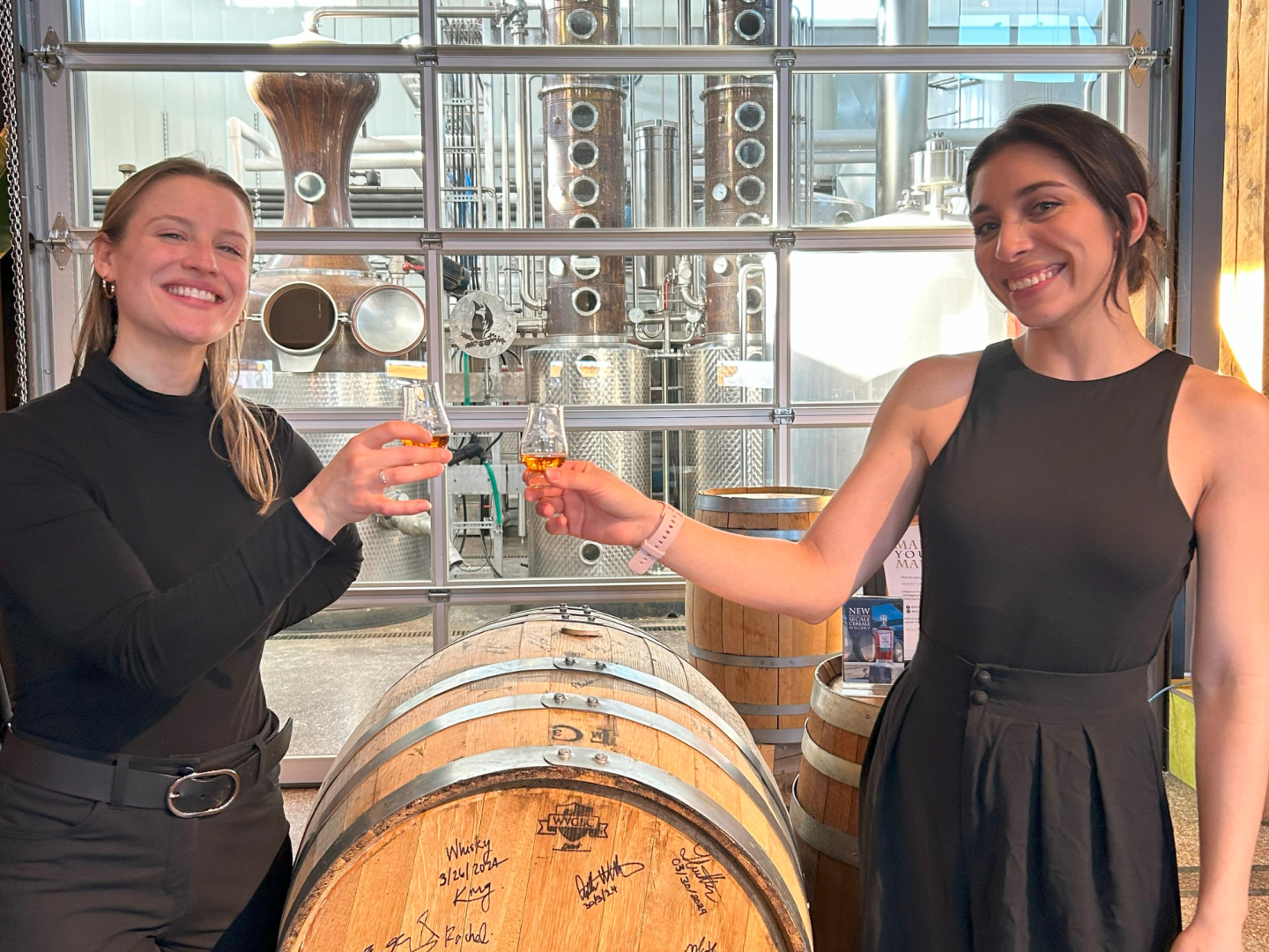 Whisky Glencairn glass filled with whisky with two smiling females celebrating event.