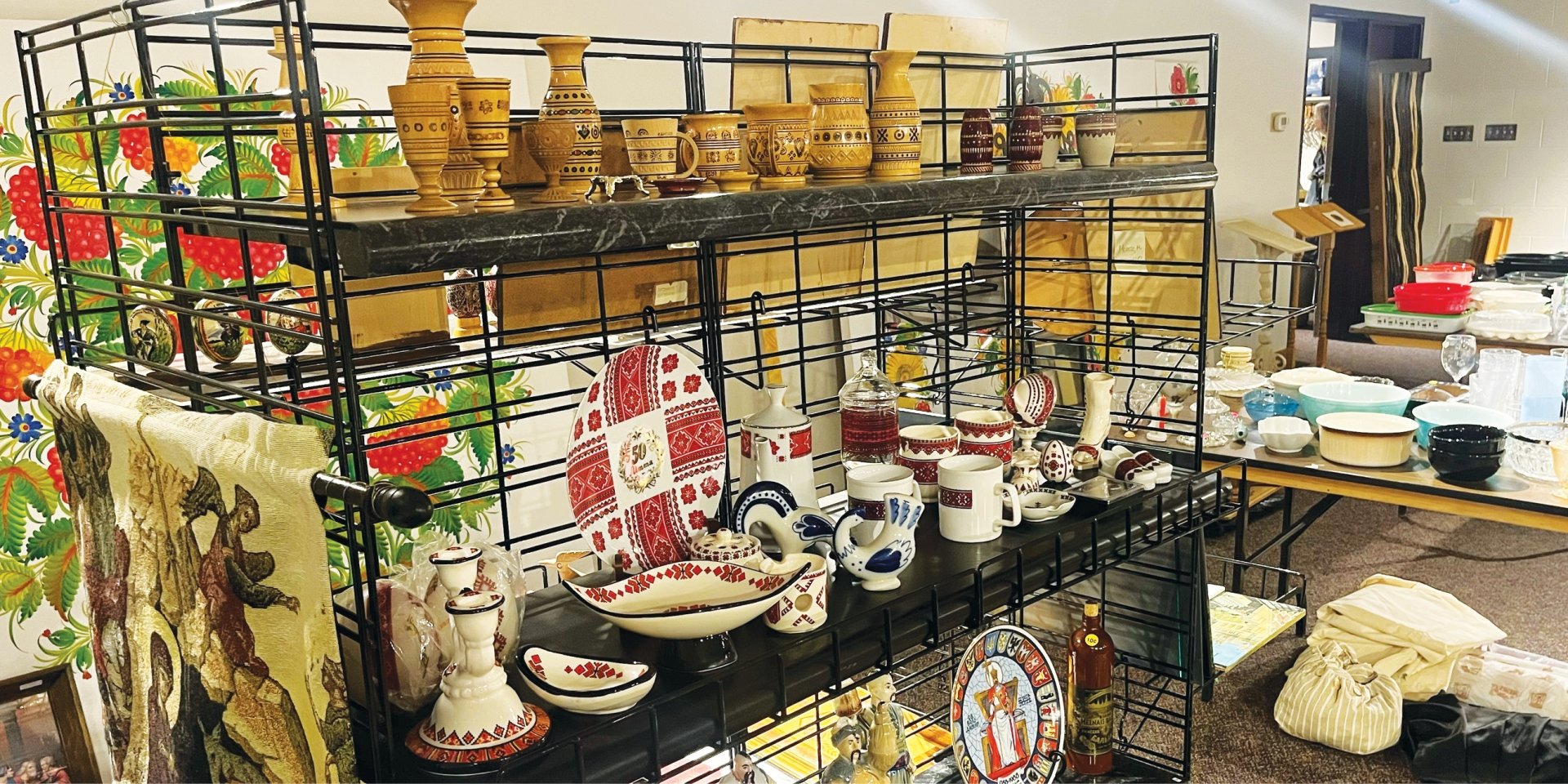 image of various Ukrainian plates, cups, and other dishes on a wire shelf