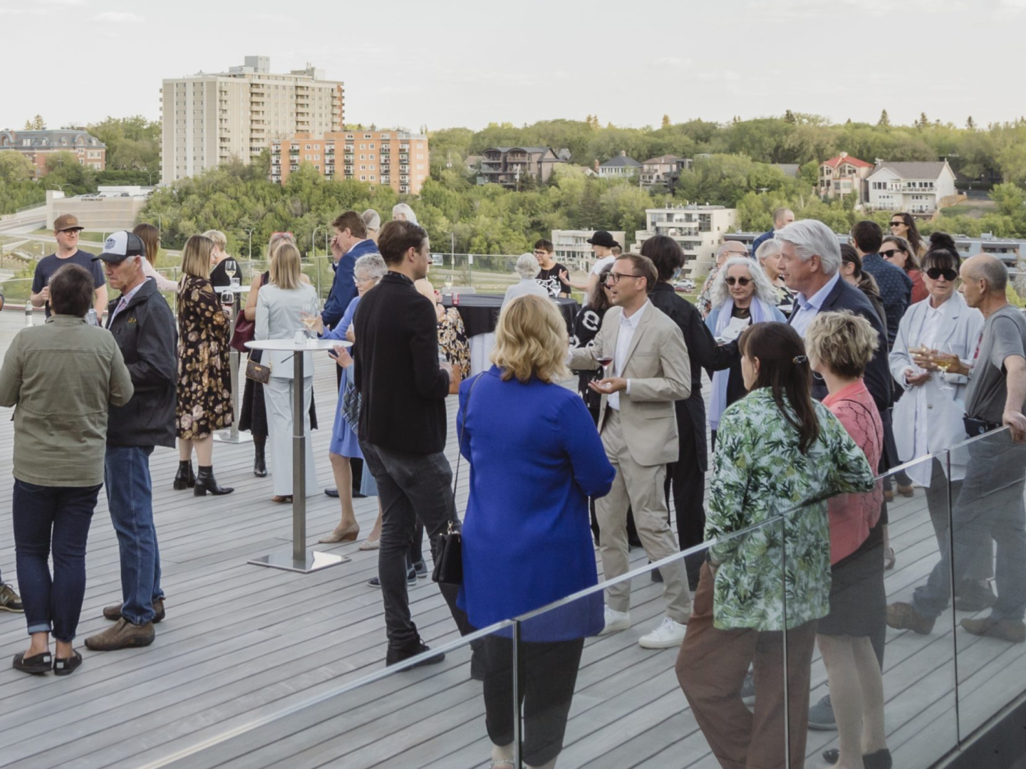 Friends gathering enjoying cocktails viewing the South Saskatchewan River from the rooftop terrace at Remai Modern.
