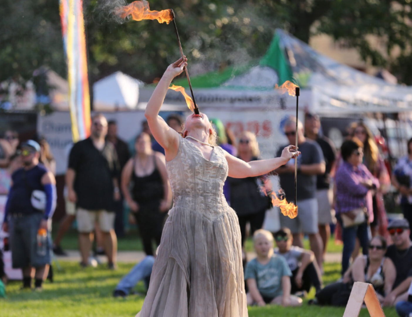 A person swallowing a stick on fire in the summer.