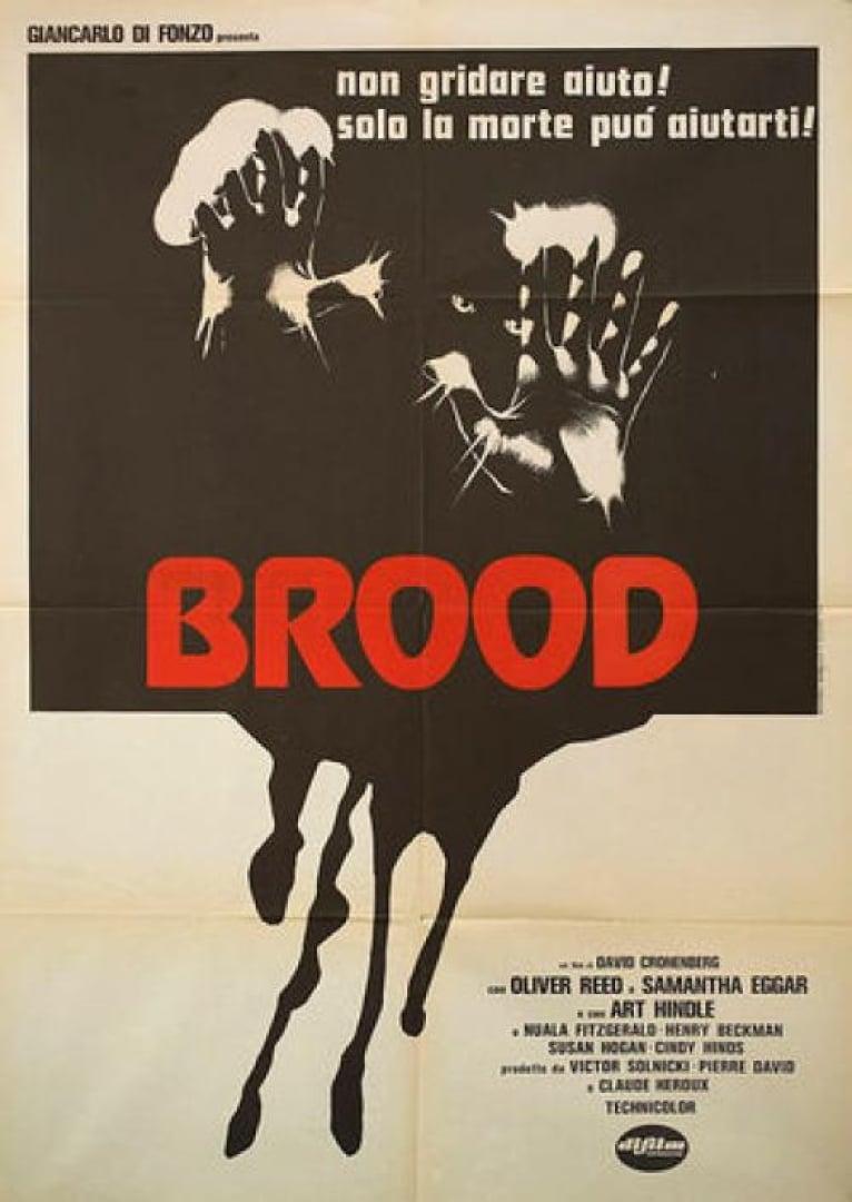 Image from the movie; the brood. Hands are pressed up against the picture with light at the fingertips and creepy eyes in the background. 
