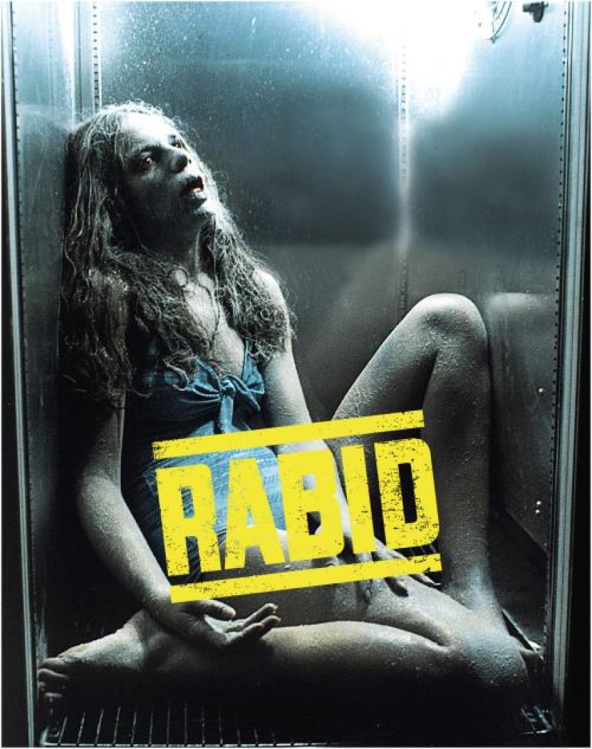 Image from the movie; rabid. Shows a girl in a blue dress frozen with her mouth open, in a small fridge possibly. 