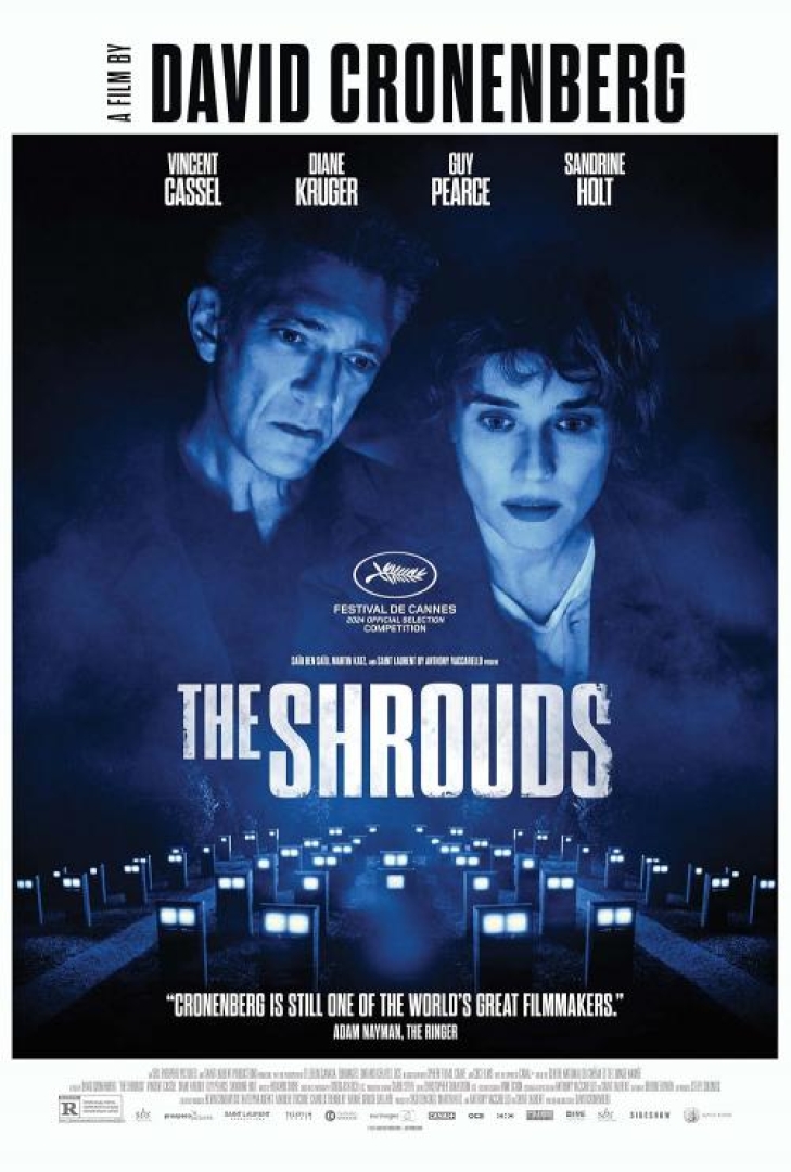 Image from the movie The Shrouds with two of the actors overlooking rectangular graves with lights on them. 