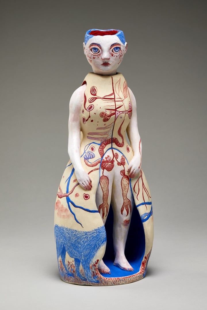 "Anasyrma" by Maia Stark, a clay sculpture of a human figure, wearing a long cream dress with red and blue details.