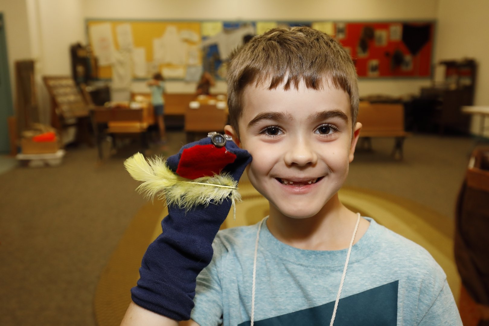 Boy smiling with a homemade sock puppet on his hand