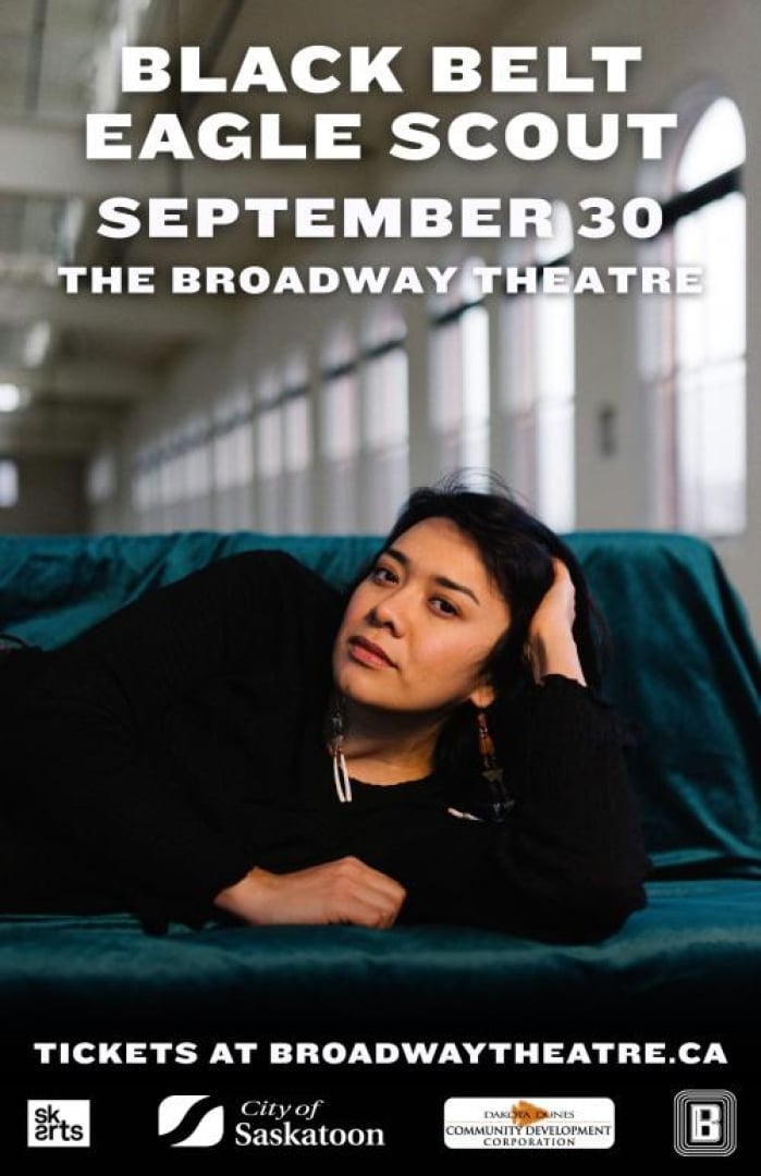 Image of Black Belt Eagle Scout Kathrine Paul Laying on her side on a couch in a long hallway. Text is written: Black Belt Eagle Scout September 30 The Broadway Theatre Tickets at broadwaytheatre.ca