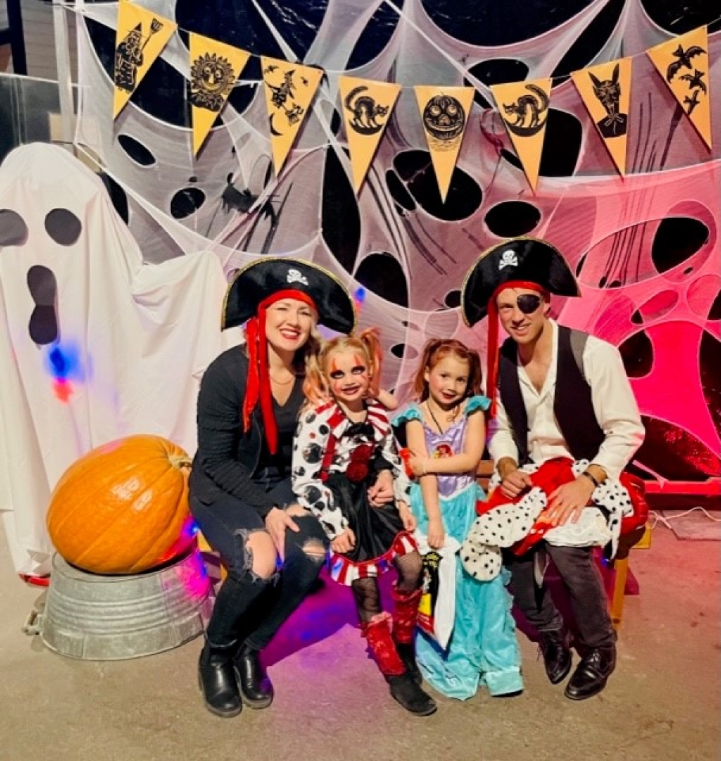 Family seated posing for a photo in Halloween costumes