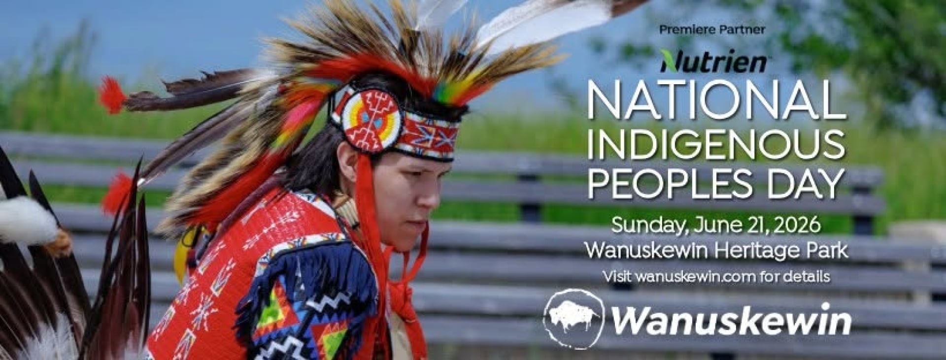 A promotional banner for National Indigenous Peoples Day at Wanuskewin Heritage Park. The image features a dancer in vibrant traditional regalia with a feather bustle and beaded headdress, captured during a cultural performance. Text on the right reads: “National Indigenous Peoples Day, Sunday, June 21, 2026, Wanuskewin Heritage Park. Visit wanuskewin.com for details.” The Nutrien logo appears as the Premier Partner, alongside the Wanuskewin logo. The background shows an outdoor setting with a wooden fence 