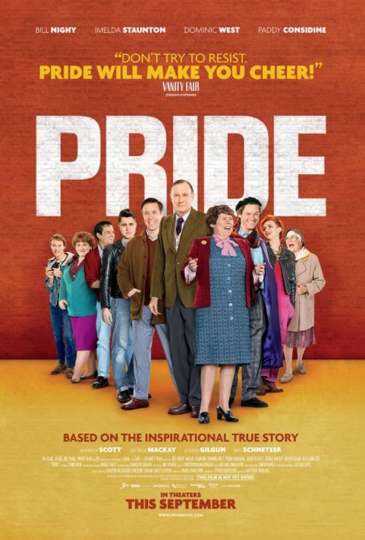 Image of ensemble cast from the movie PRIDE, standing one after the other, posing and smiling.