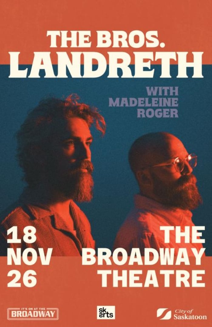 Image of the singer duo The Bros Landreth, baked in orange light and looking off to the distance. 