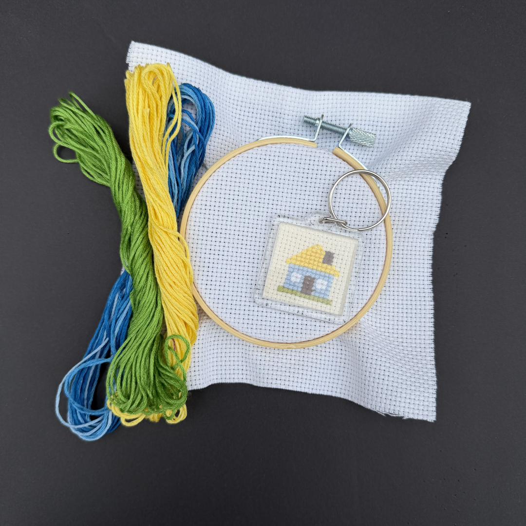An image of embroidered keychain (Ukrainian house) and materials