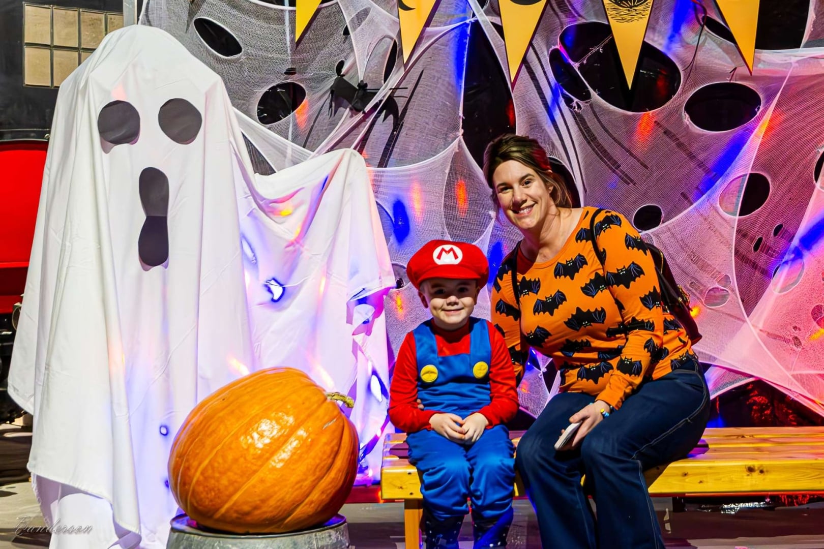 People in costume getting their picture taken with a ghost