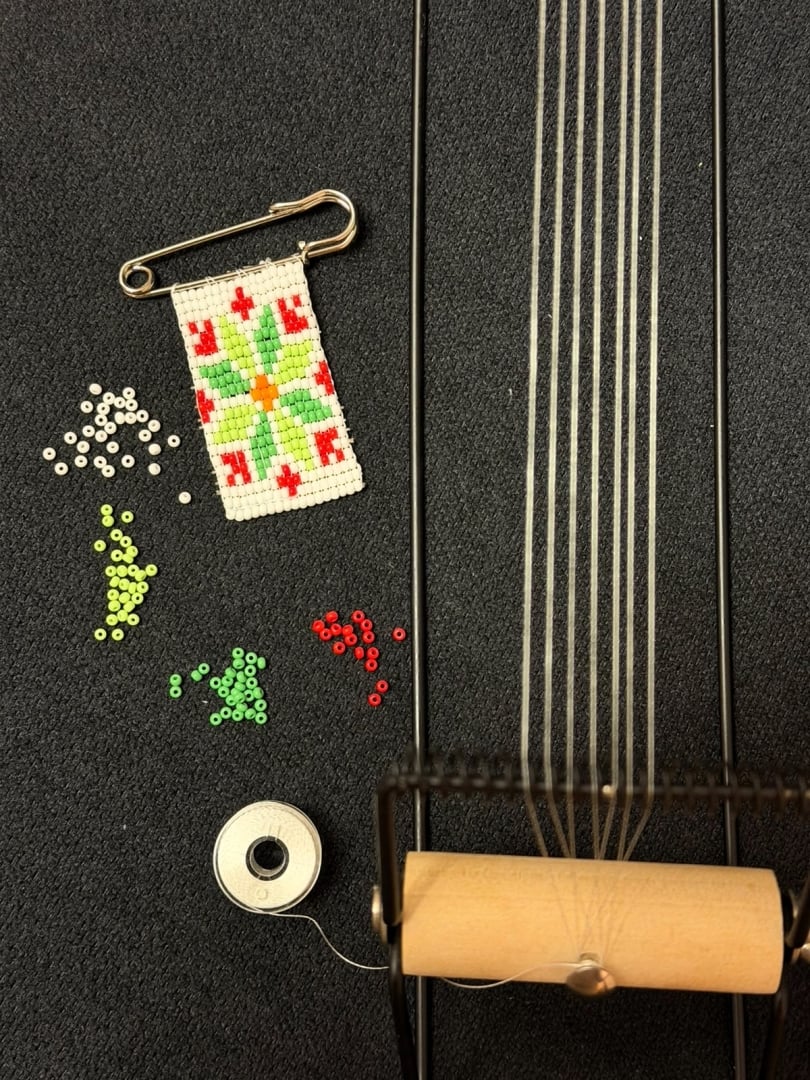 Staged photo of the final product (cotillion), beads, thread, and bead loom