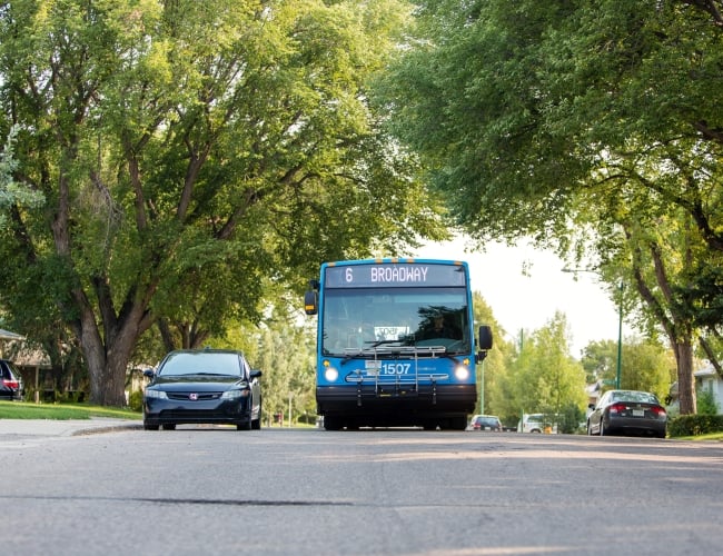 A public transit bus driving down the street. The sign