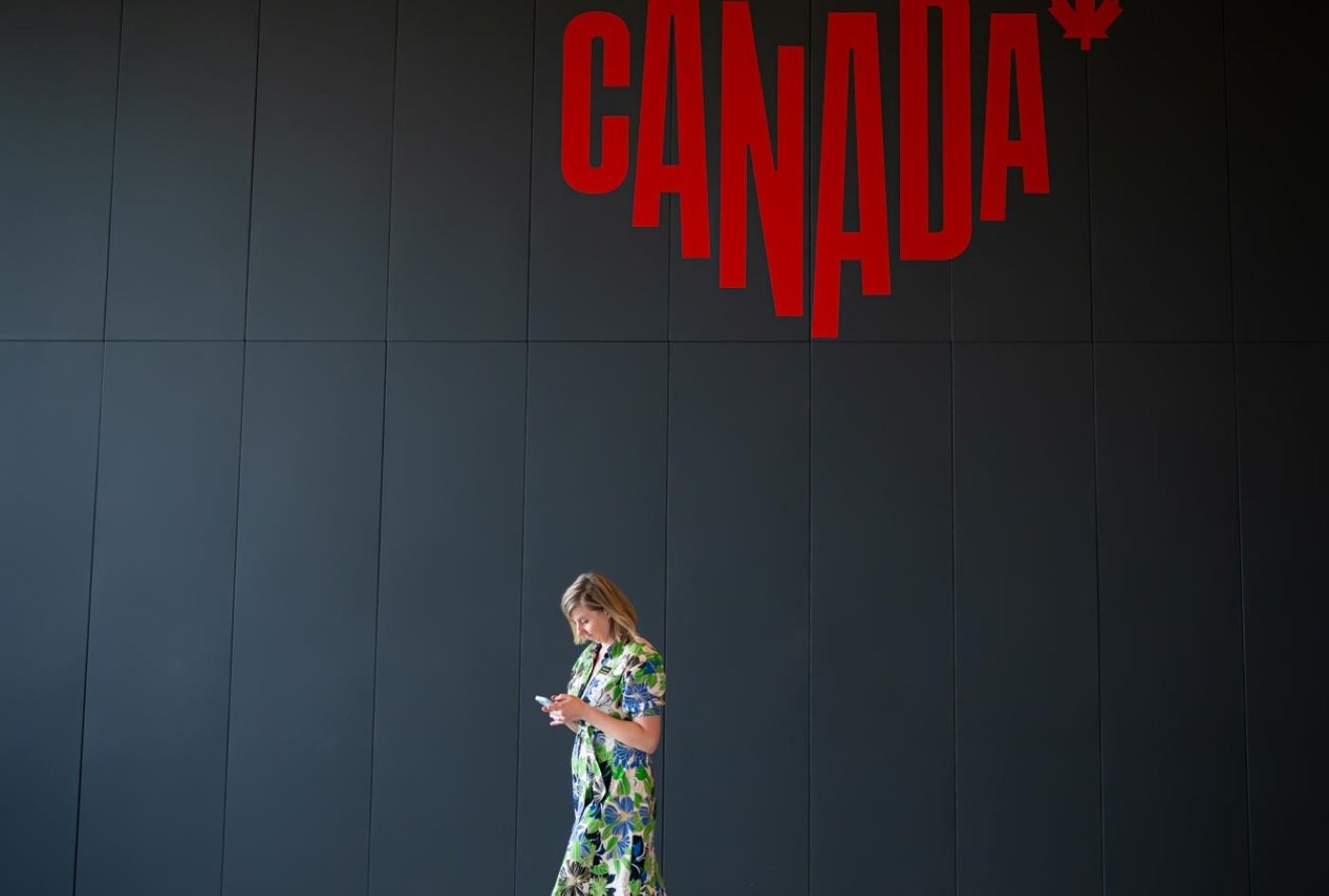 woman walking by Canada sign at Remai Modern